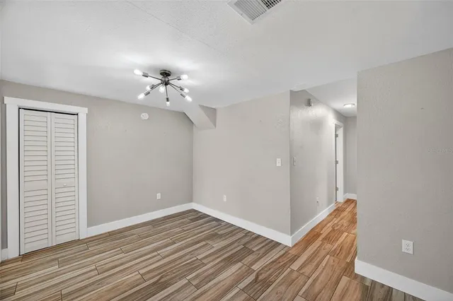 a view of a room with wooden floor and a ceiling fan