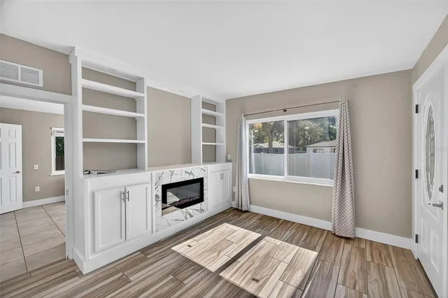 a living room with stainless steel appliances furniture a rug and a window