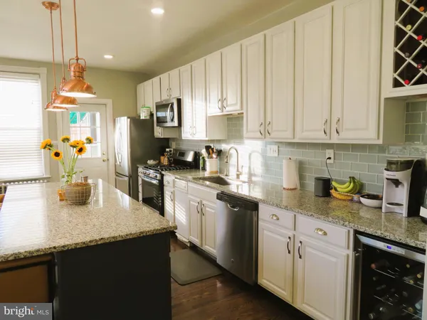 a kitchen with granite countertop a sink a stove and cabinets