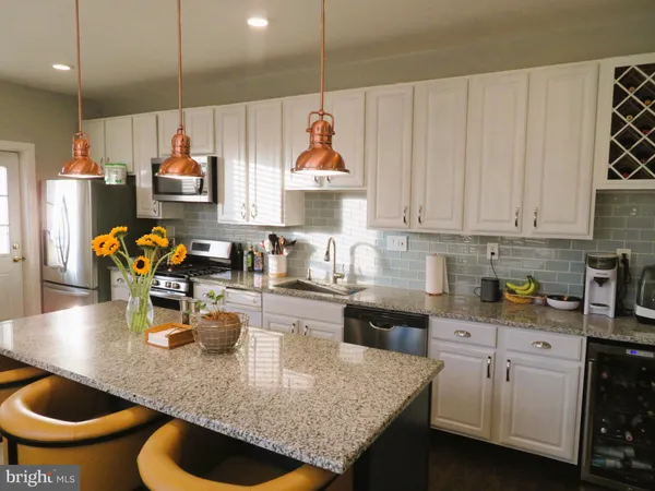 a kitchen with white cabinets and sink