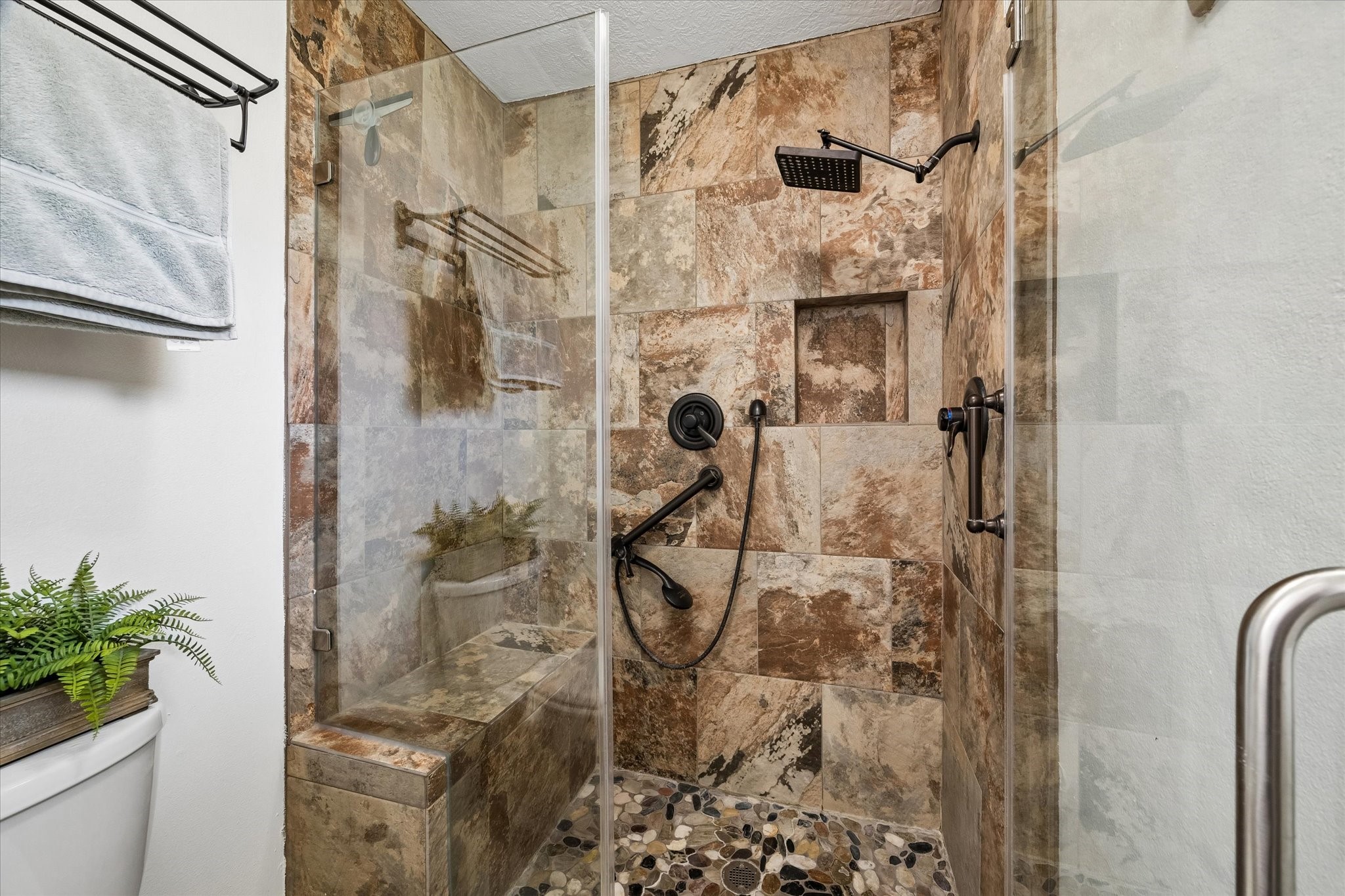 1931 Westlake Road Houston, TX 77062 - Photo 21 of 28 This oversized walk-in shower brings the spa experience home with beautiful tile work, frameless glass, a built-in bench, shampoo niche, rain shower and handheld spray. It’s the kind of upgrade you will appreciate both morning and night.