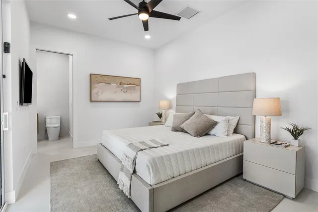 a bedroom with a large bed and a chandelier