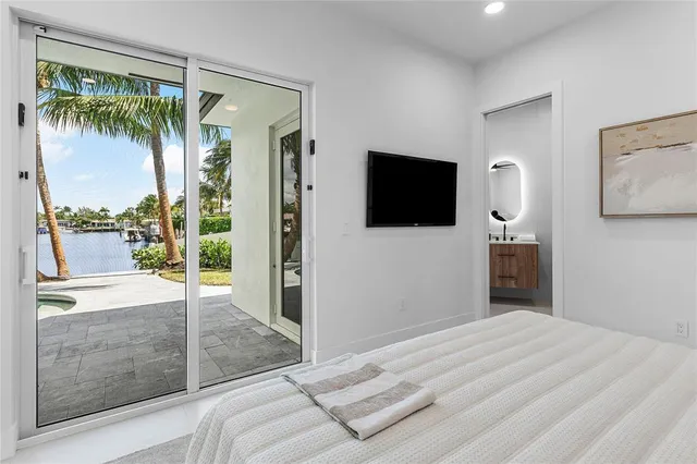 a bedroom with a bed and a flat tv screen on the dresser