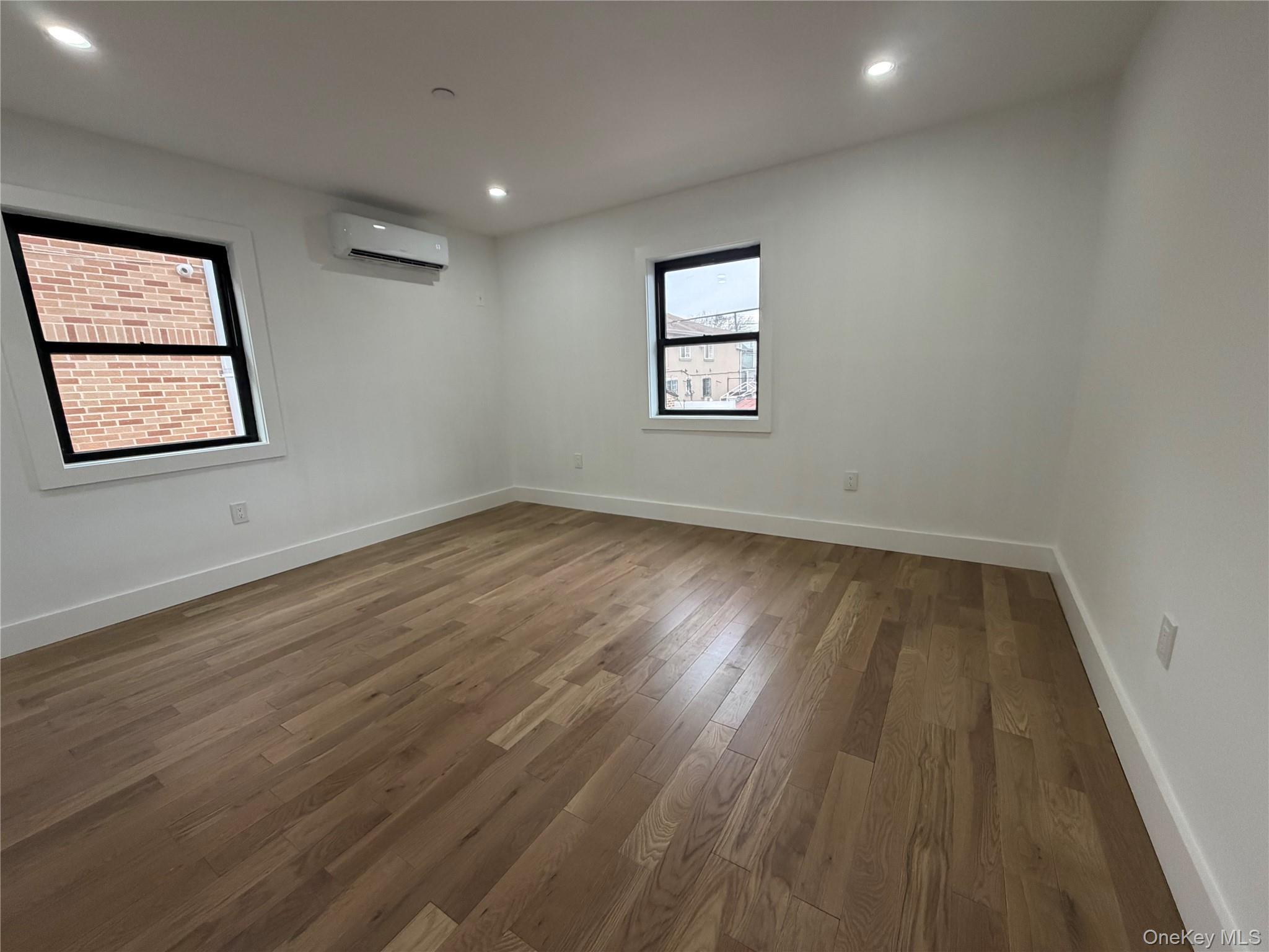 126-22 146th Street Queens, NY 11436 - Photo 13 of 20 wooden floor in an empty room with a window