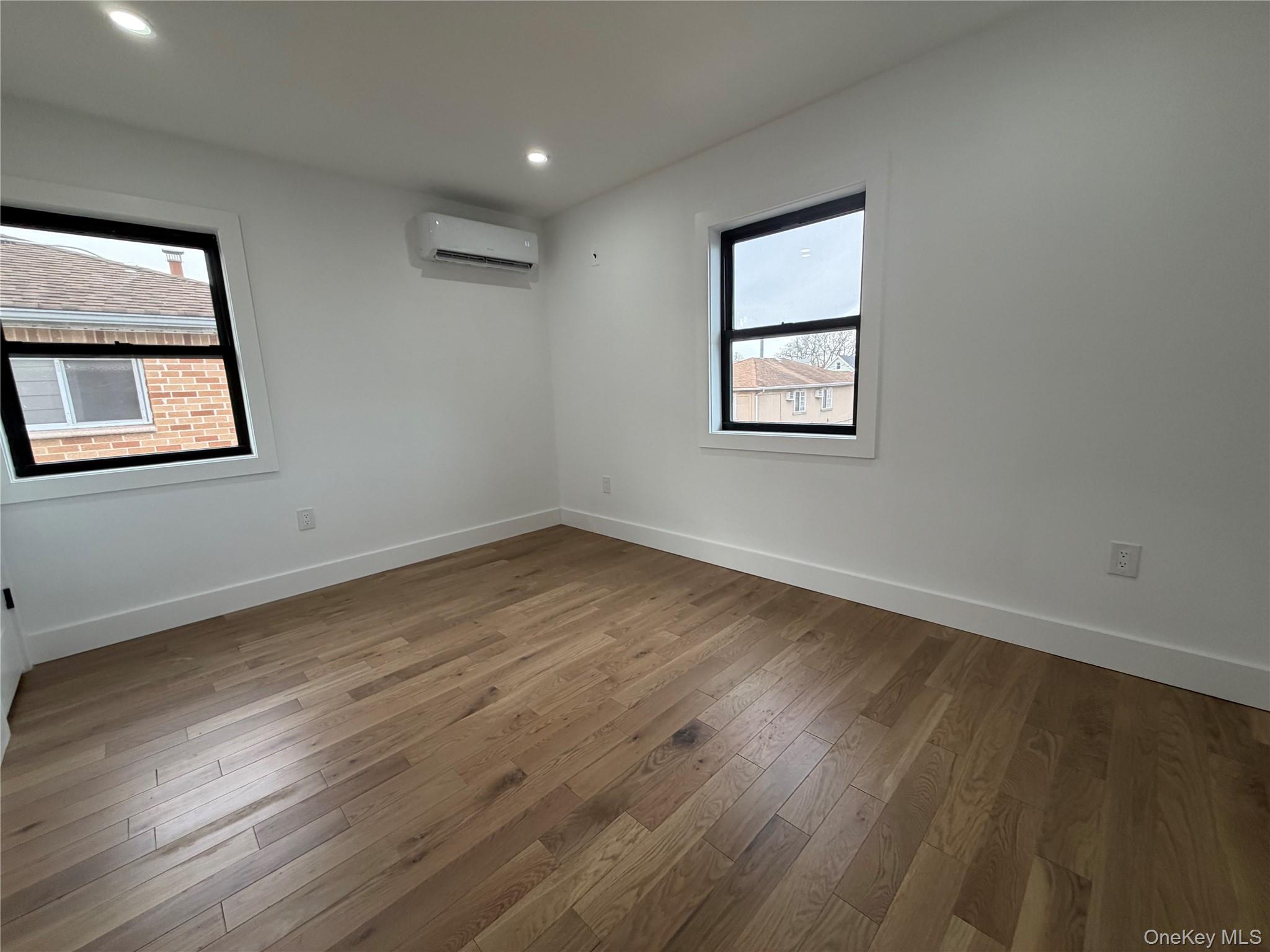 126-22 146th Street Queens, NY 11436 - Photo 16 of 20 a view of an empty room with wooden floor and a window