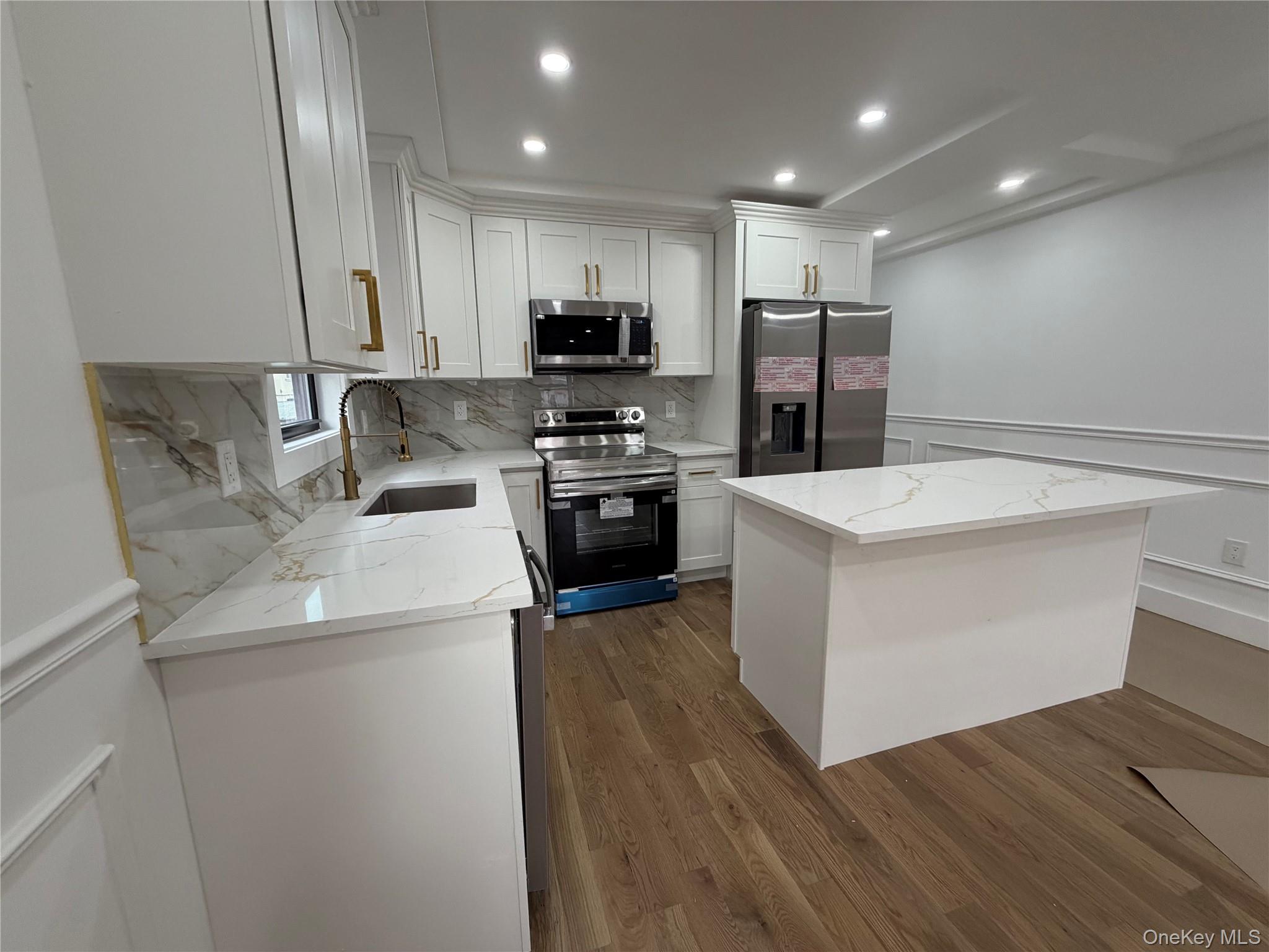 126-22 146th Street Queens, NY 11436 - Photo 5 of 20 a kitchen with wooden cabinets and stainless steel appliances