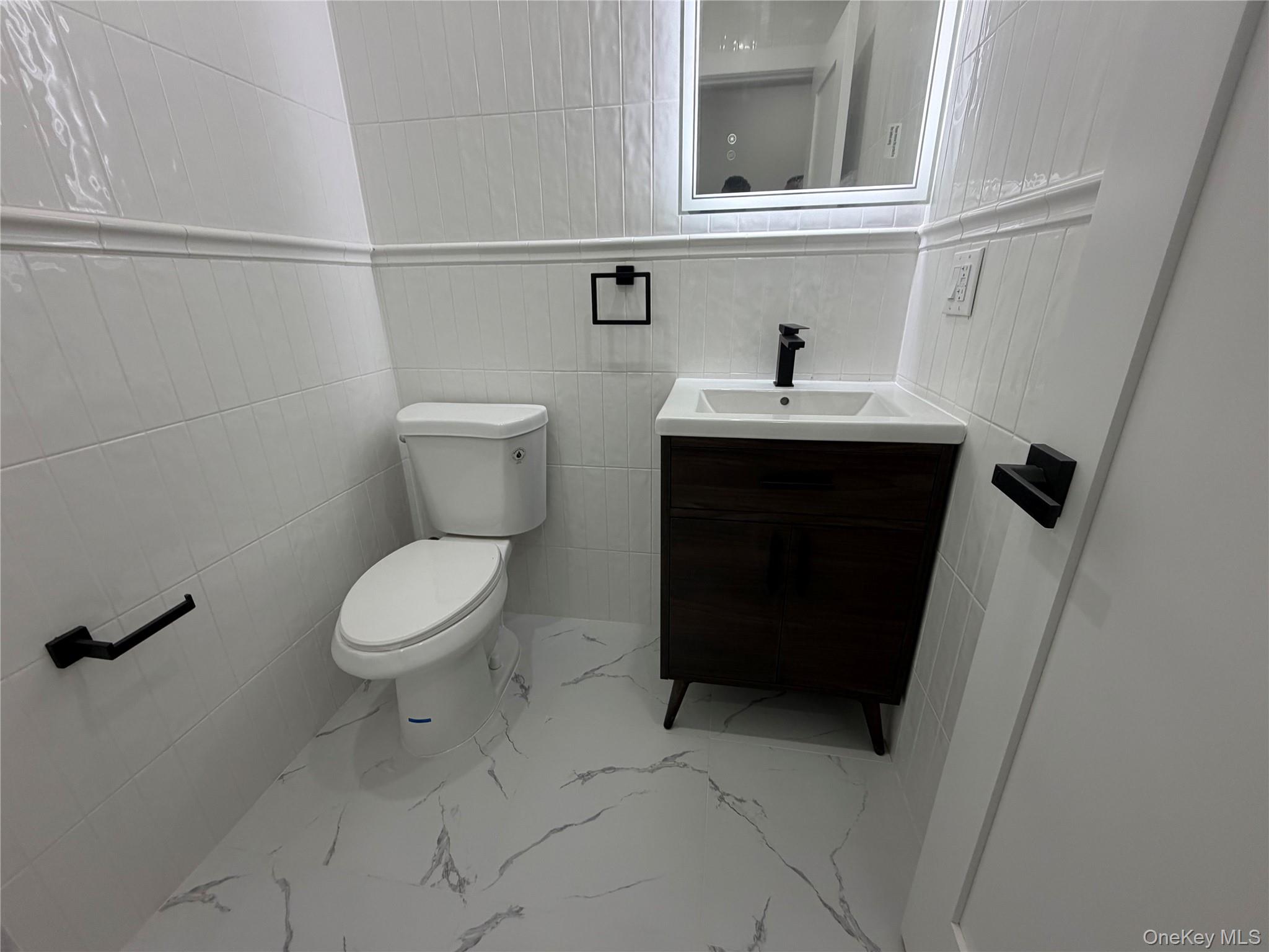 126-22 146th Street Queens, NY 11436 - Photo 9 of 20 a bathroom with a toilet a sink and mirror