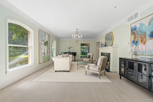 a living room with furniture a fireplace and a chandelier