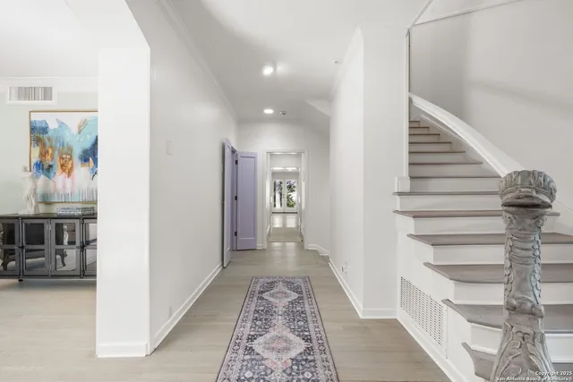 a view of a hallway to rooms and stairs