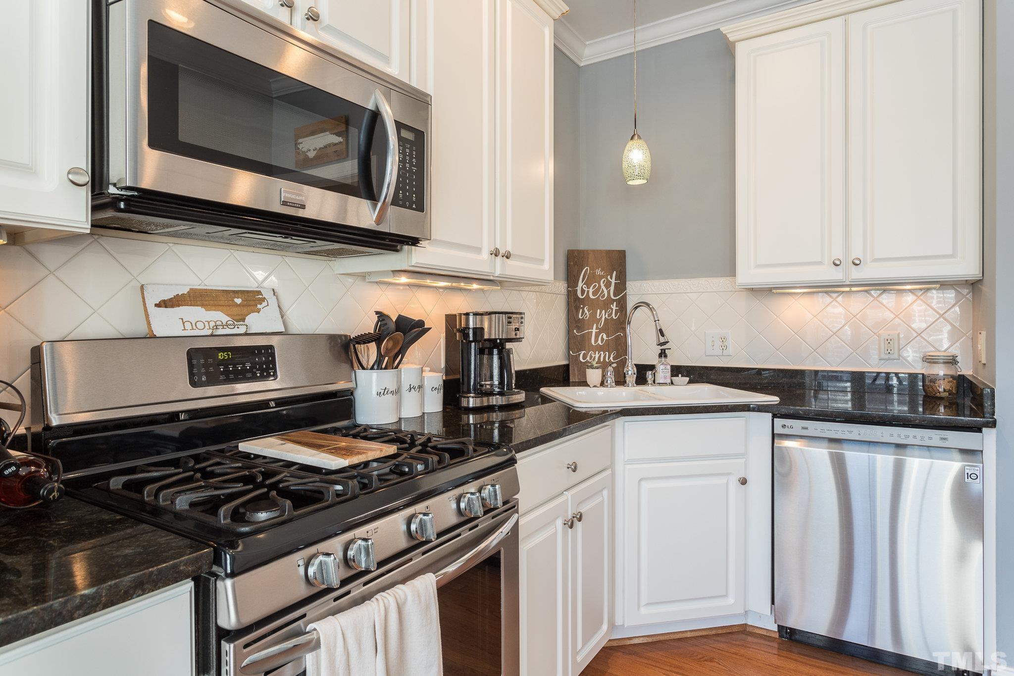 1311 Cameron View Court Raleigh, NC 27607 - Photo 8 of 33 a kitchen with granite countertop a stove and a microwave