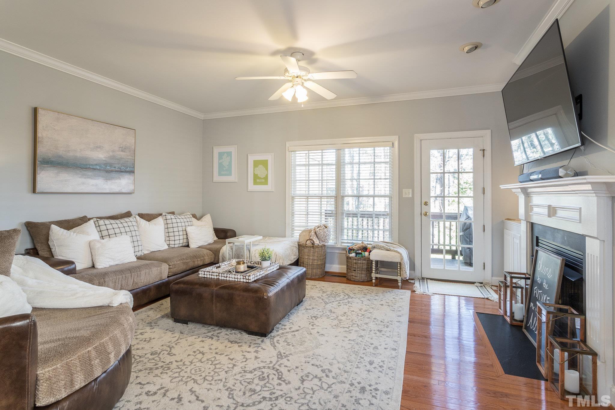 1311 Cameron View Court Raleigh, NC 27607 - Photo 10 of 33 a living room with furniture a fireplace and a flat screen tv