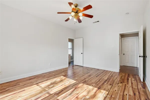 a view of a room with wooden floor and a ceiling fan