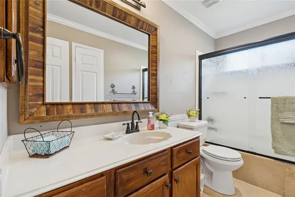 a bathroom with a granite countertop sink a toilet and mirror