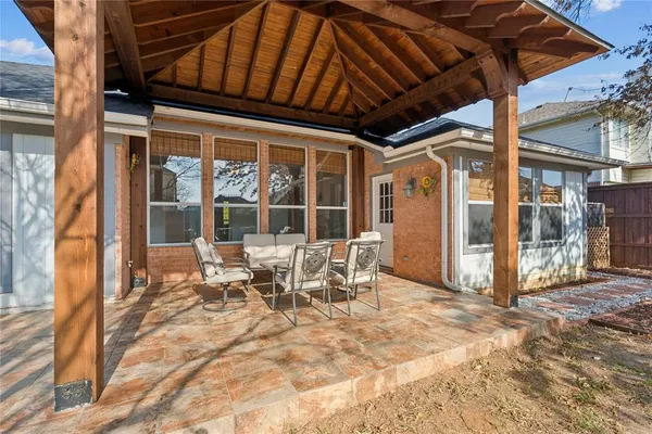 a view of a patio with table and chairs and floor to ceiling window