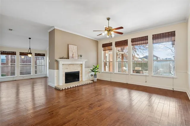 a view of a livingroom with wooden floor a fireplace and windows