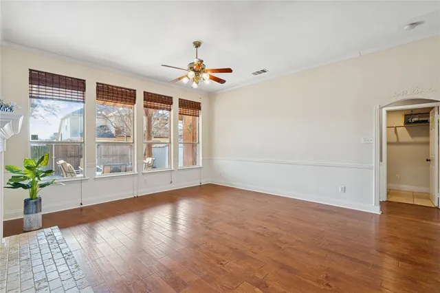 a view of an empty room with a window and wooden floor