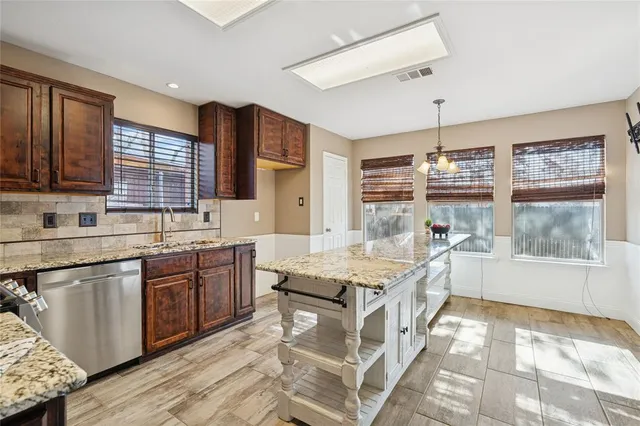 a kitchen with granite countertop a sink stove and cabinets