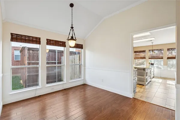 a view of a room with wooden floor and a window