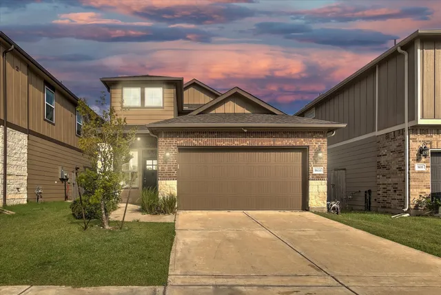 a front view of a house with a yard and garage