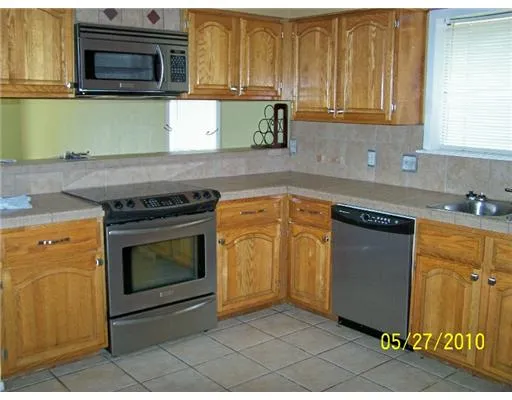 a kitchen with granite countertop cabinets stainless steel appliances and a counter space