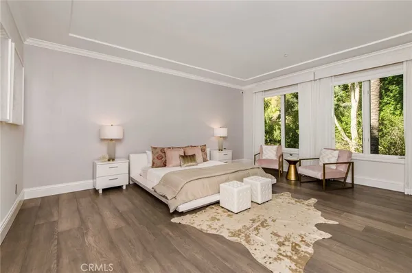 a spacious bedroom with a bed and wooden floor