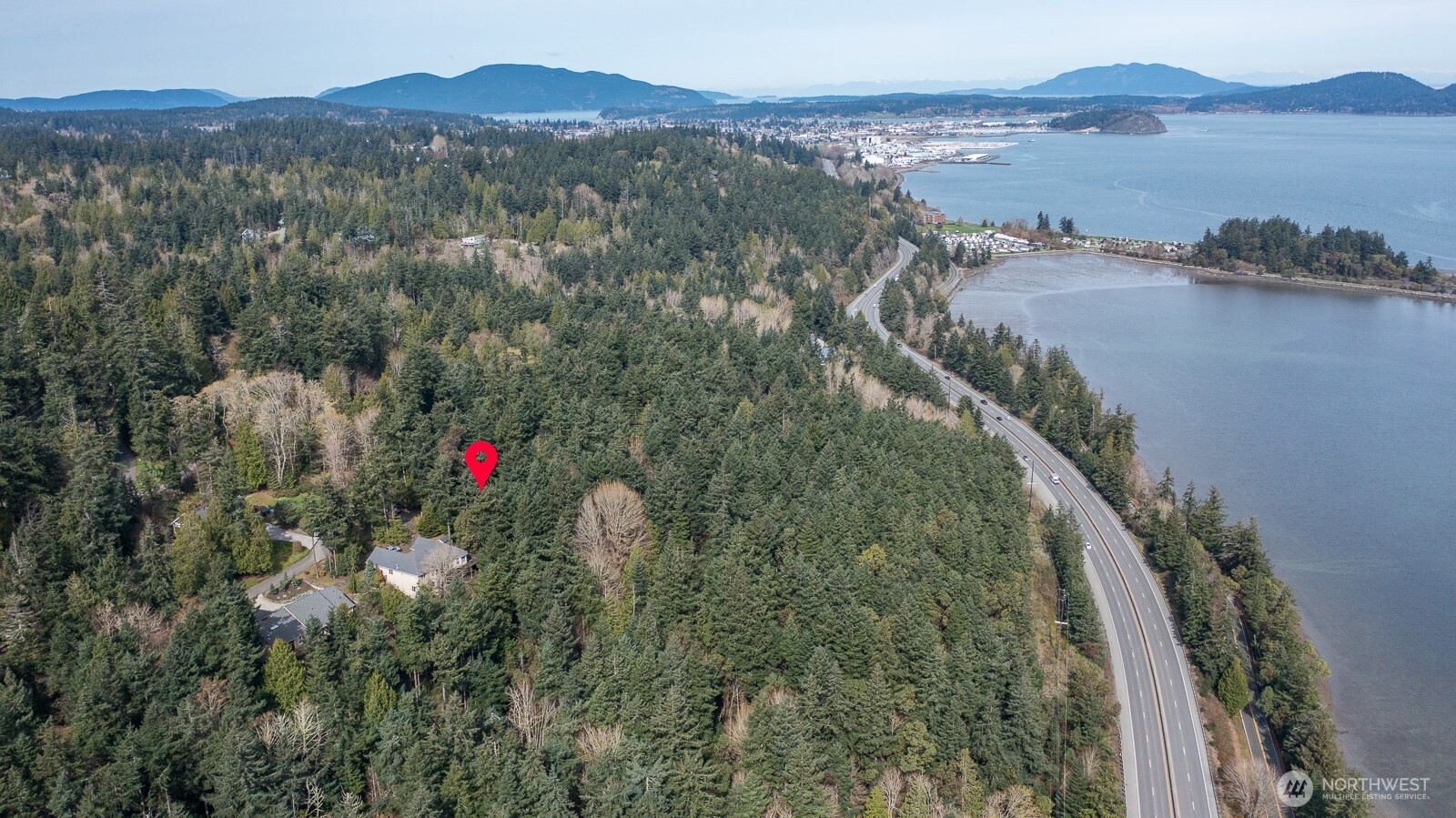 11711 Hummingbird Lane Anacortes, WA 98221 - Photo 2 of 14 a view of a house with a mountain and a forest