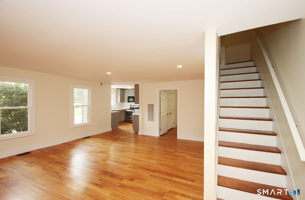 141 Duck Hole Road Madison, CT 06443 - Photo 8 of 22 a view of empty room with wooden floor and windows