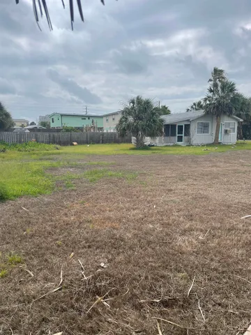 a view of a big house with a big yard and large trees