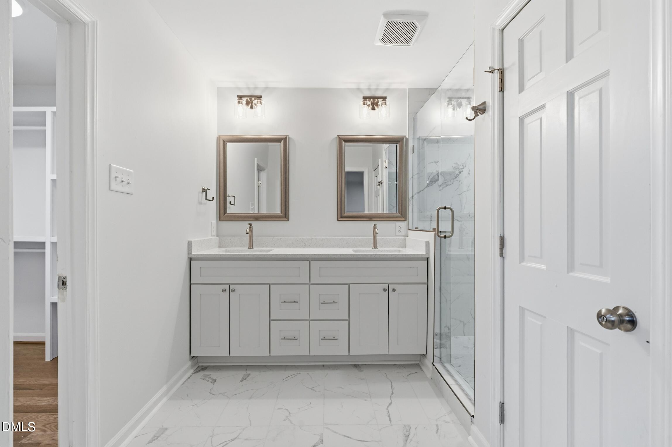 1504 Homestead Road Chapel Hill, NC 27516 - Photo 12 of 39 a spacious bathroom with a double vanity sink a mirror and a shower