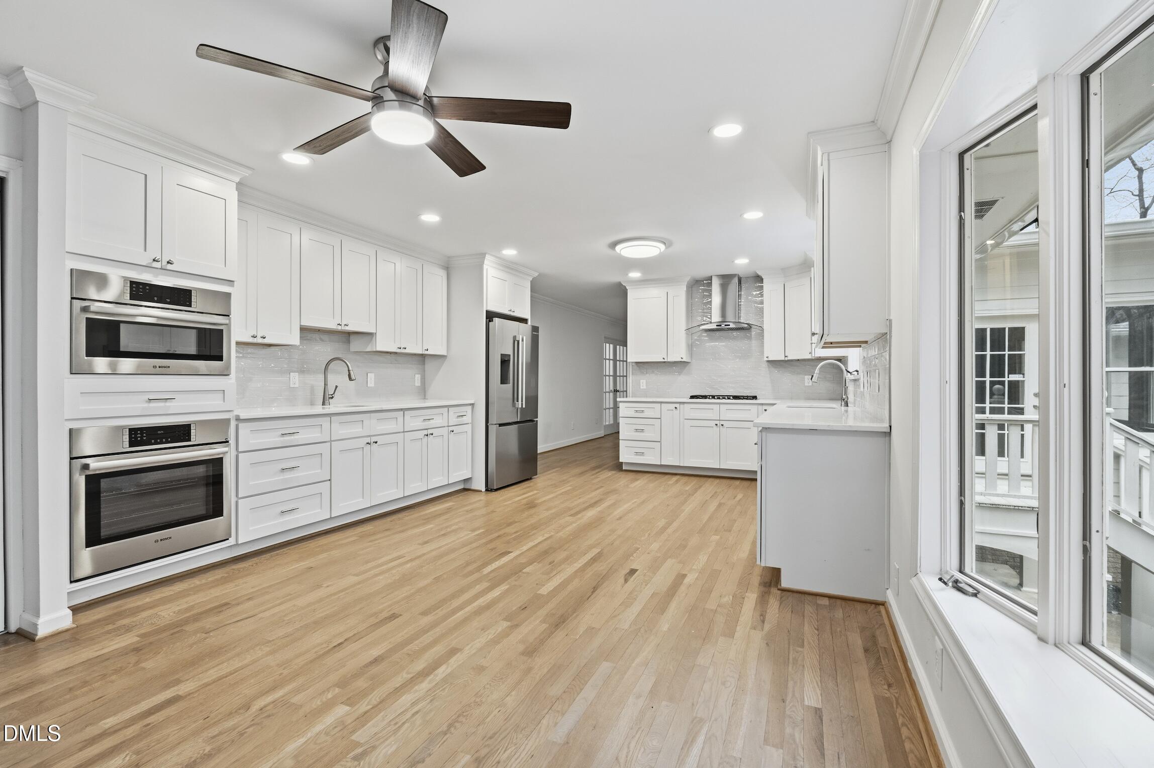1504 Homestead Road Chapel Hill, NC 27516 - Photo 22 of 39 a large kitchen with cabinets wooden floor and stainless steel appliances