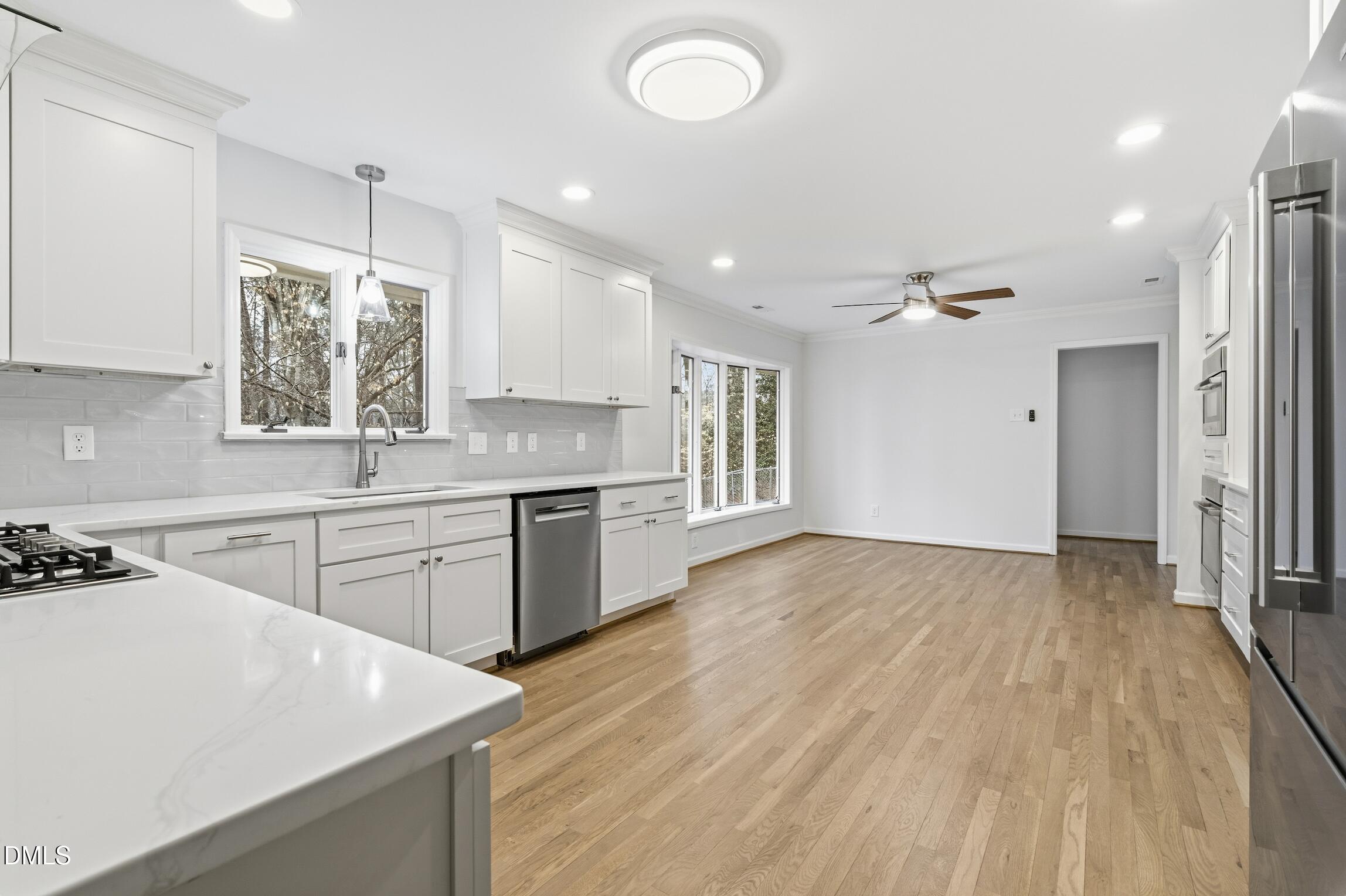 1504 Homestead Road Chapel Hill, NC 27516 - Photo 24 of 39 a kitchen with granite countertop a stove a sink dishwasher and a refrigerator with wooden floor