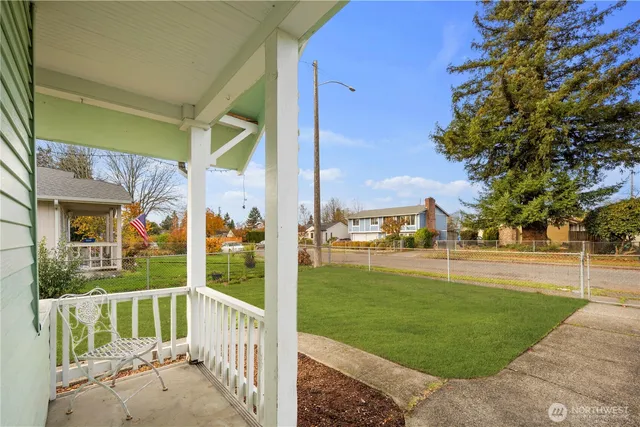 a view of a deck with a big yard potted plants and large tree