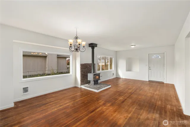 a view of a livingroom with a chandelier and wooden floor