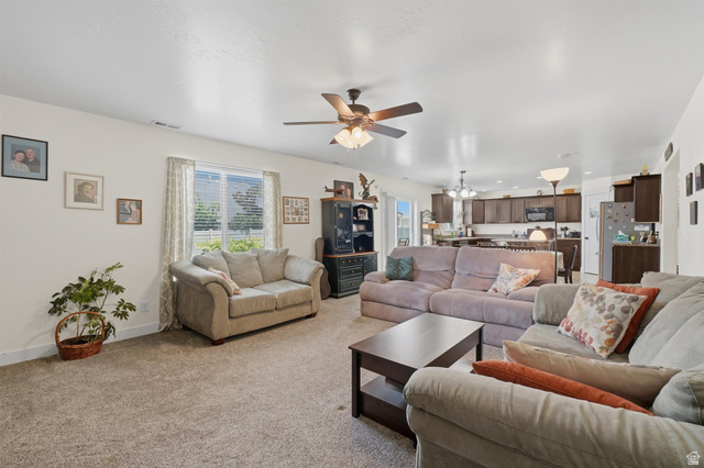 592 West 650 South Springville, UT 84663 - Photo 8 of 33 Open-concept living area with neutral carpeting, a ceiling fan, and a window with blinds