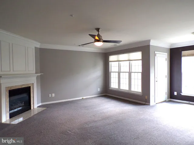a living room with a fireplace and a ceiling fan