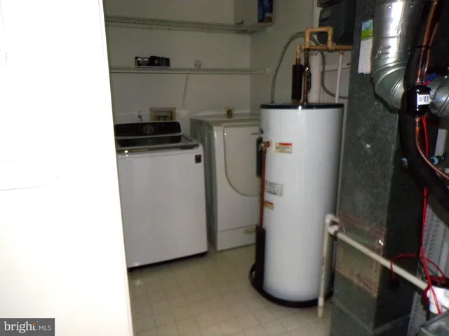 a utility room with refrigerator and washer