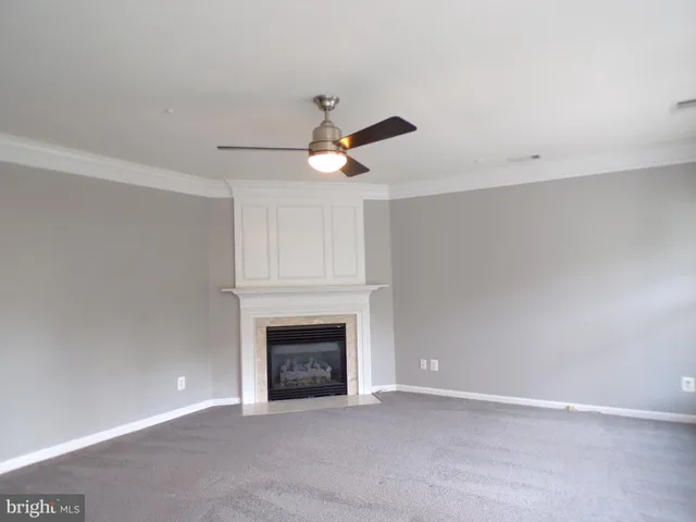 an empty room with fireplace and fan