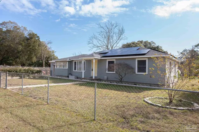 a view of a house with a backyard and a tree