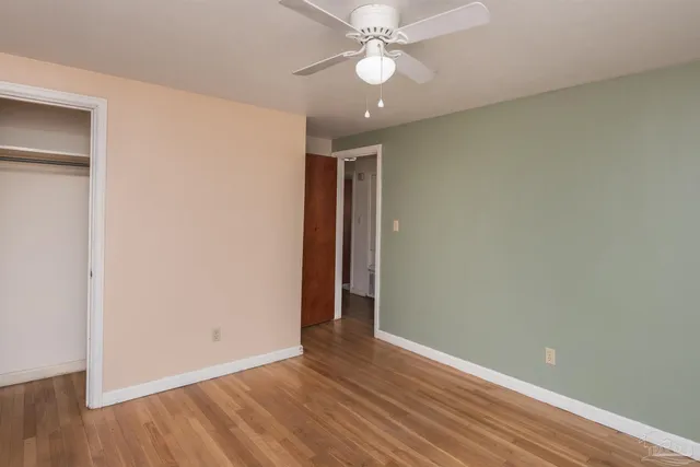 a view of an empty room with wooden floor