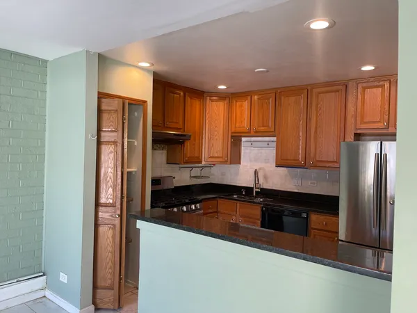 a kitchen with granite countertop a refrigerator and a sink