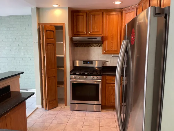 a kitchen with stainless steel appliances granite countertop a refrigerator and a stove top oven