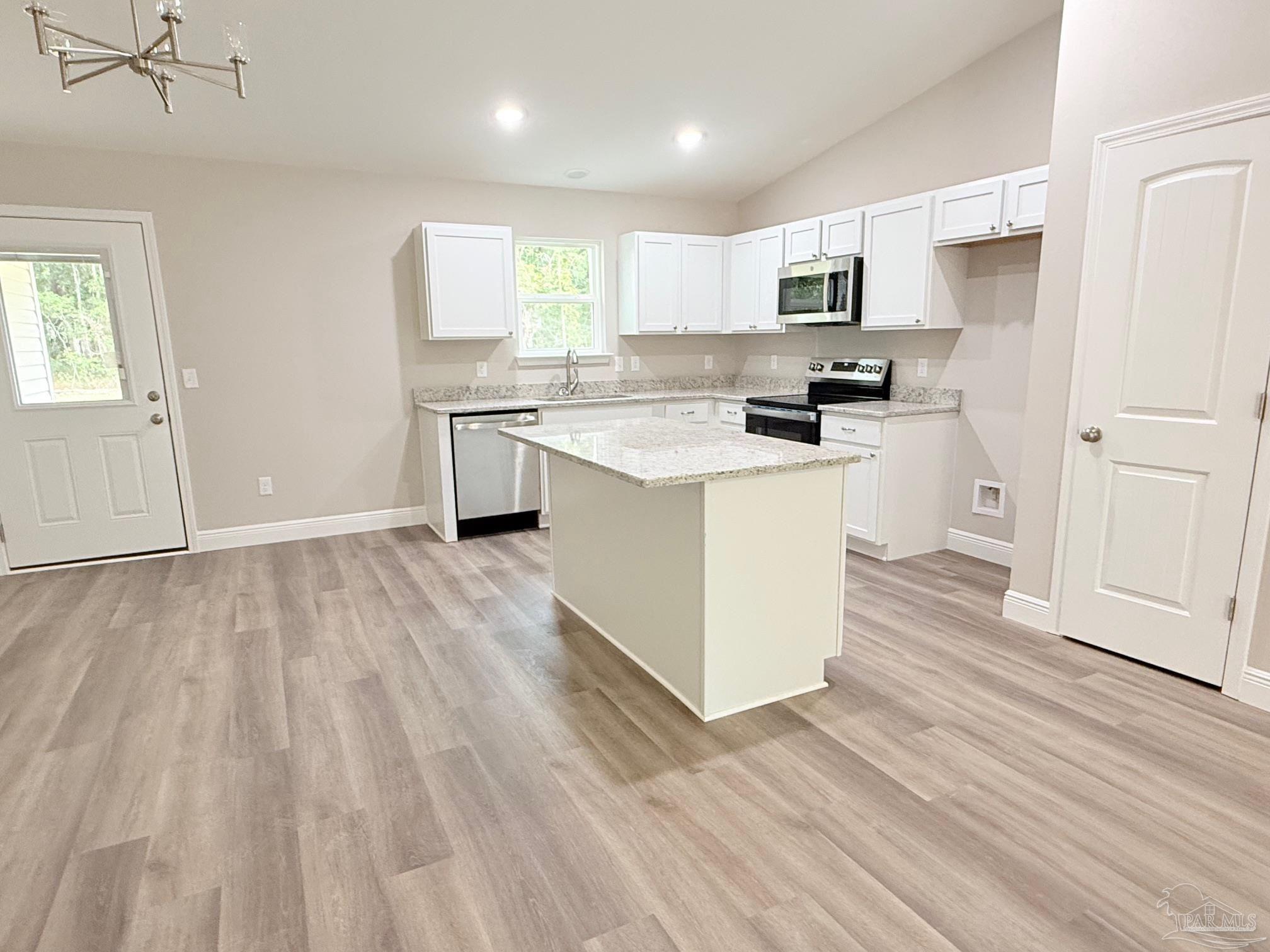 7236 Par Lane Milton, FL 32570 - Photo 2 of 10 a kitchen with a white cabinets and wooden floor