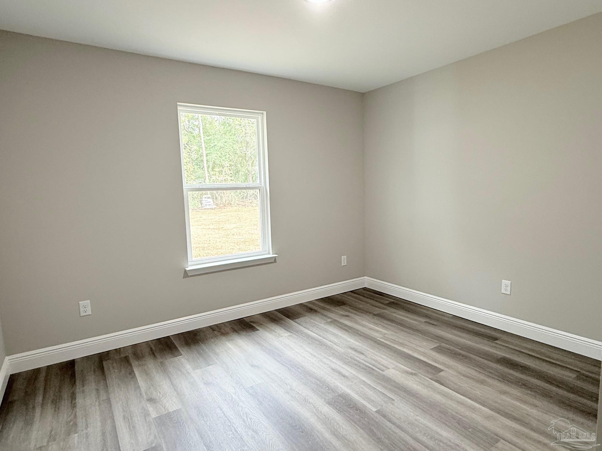 7236 Par Lane Milton, FL 32570 - Photo 7 of 10 a view of an empty room with wooden floor and a window