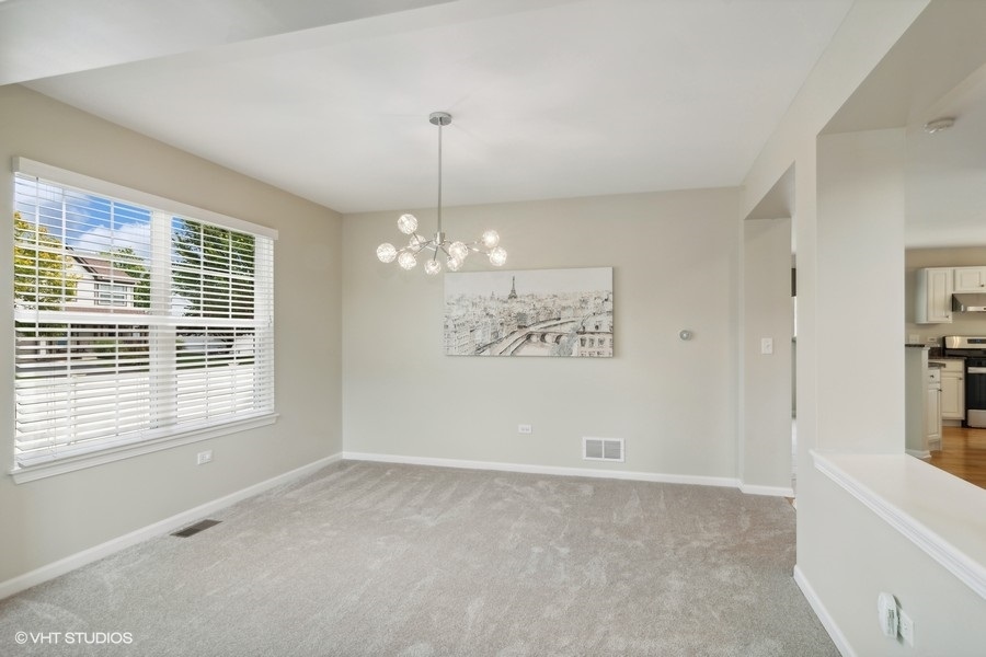 3090 Whitney Road Aurora, IL 60502 - Photo 6 of 24 a view of a livingroom with a chandelier fan and windows