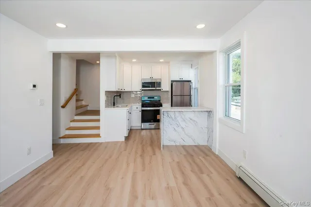 a view of a kitchen with wooden floor and electronic appliances