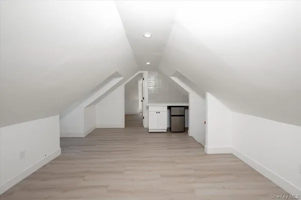 a view of an empty room with wooden floor and stairs