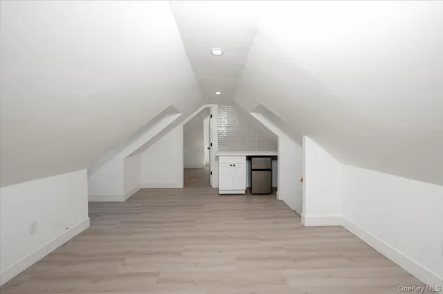 a view of an empty room with wooden floor and stairs