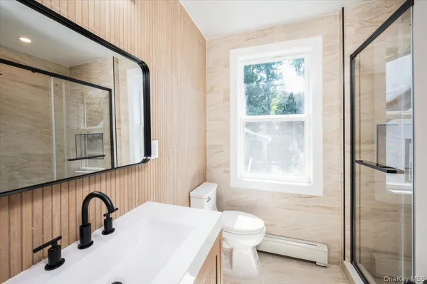 a bathroom with a sink a toilet and a window