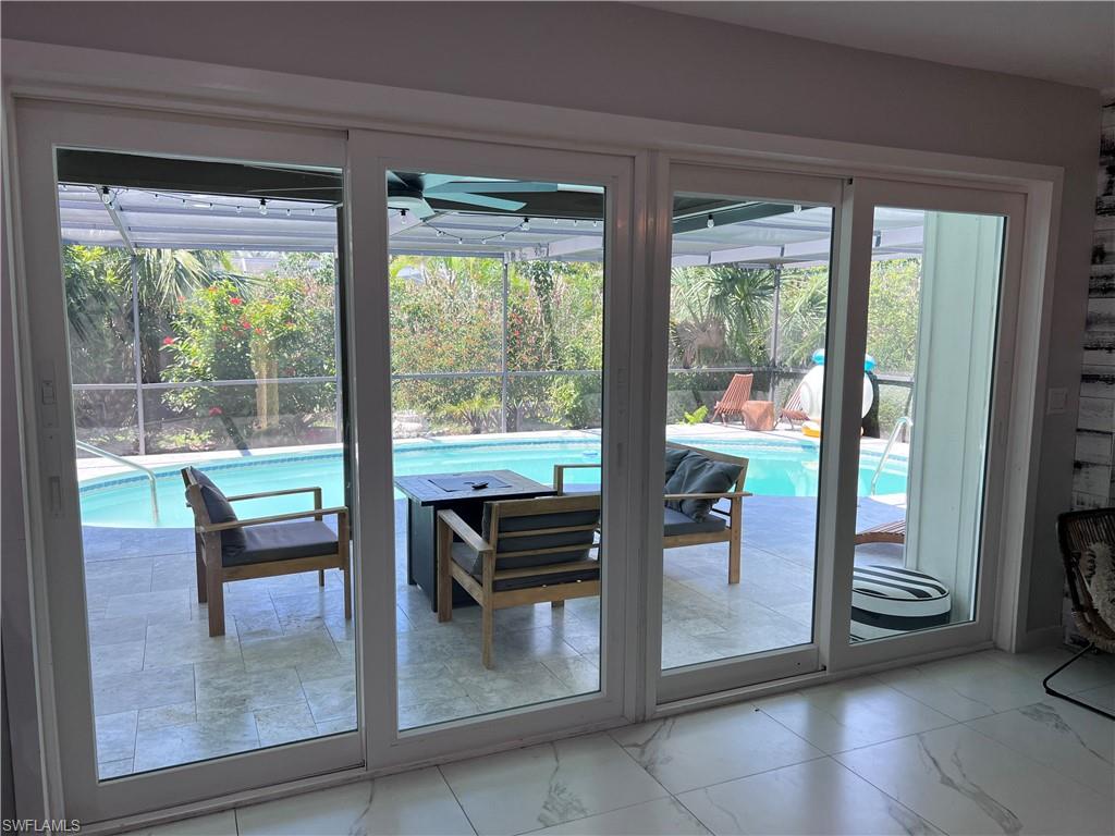 4439 Parrot Avenue Naples, FL 34104 - Photo 3 of 14 Doorway to outside featuring marble look tiles