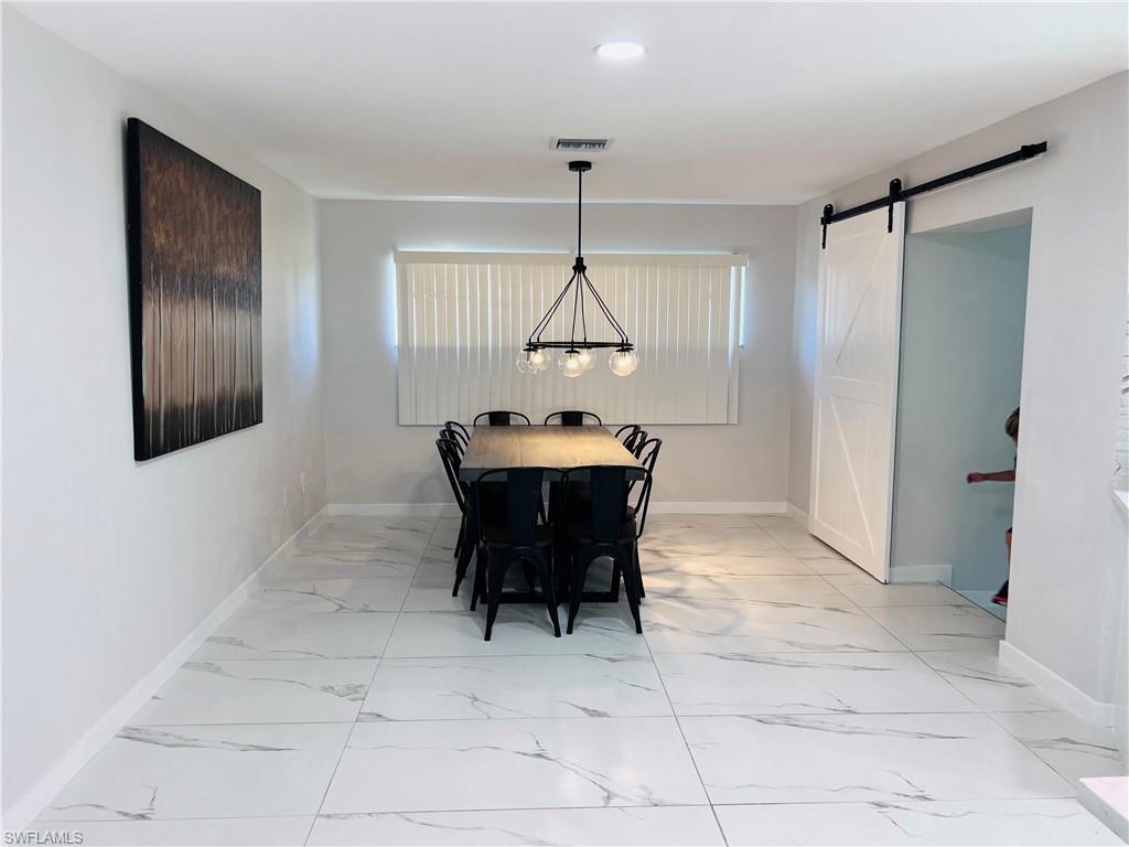 4439 Parrot Avenue Naples, FL 34104 - Photo 5 of 14 Dining space with a barn door and light marble finish flooring